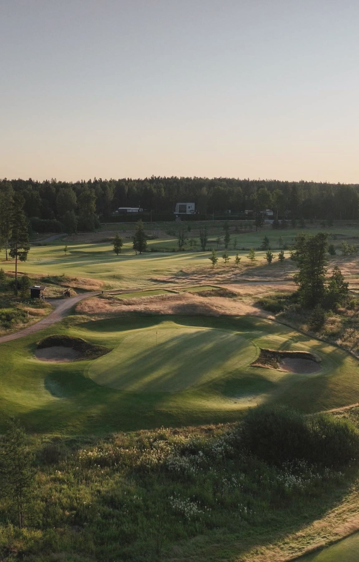 Dawn light over bunkers and greens