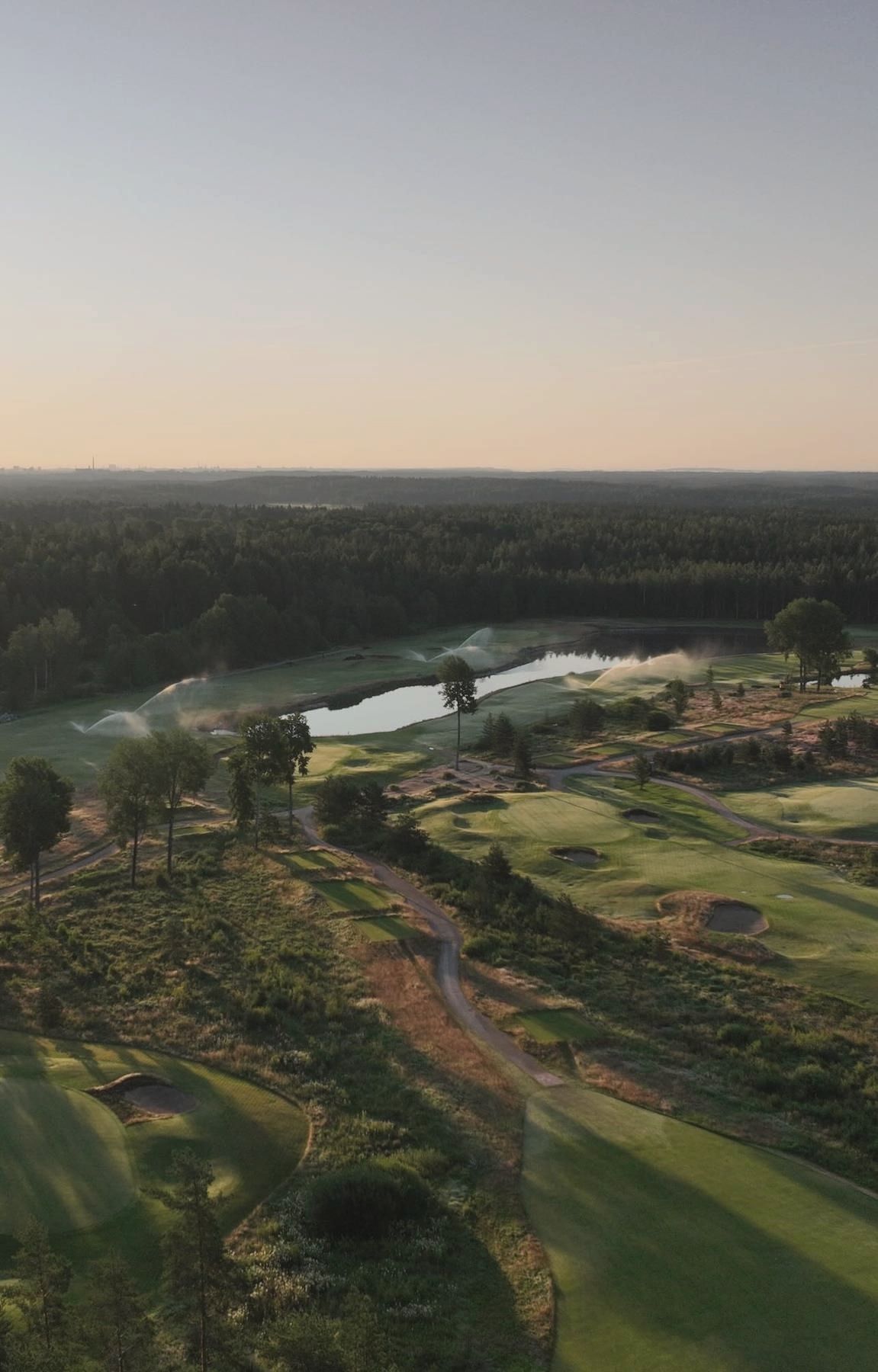 Aerial view over water, sand and turf